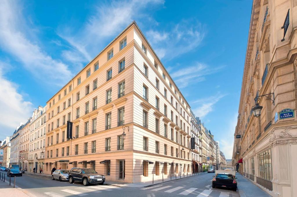 a large building on a city street with cars parked in front at Meliá Paris Vendôme in Paris