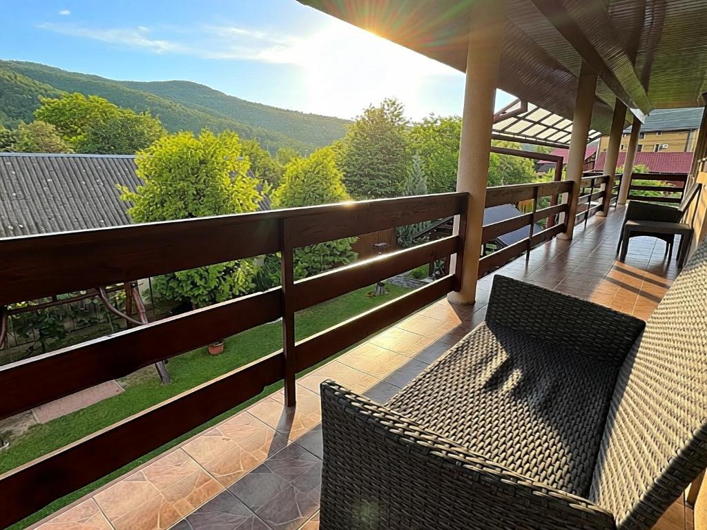 a porch with two wicker chairs and a view of the mountains at Котедж в горах у Антоніни in Solochyn