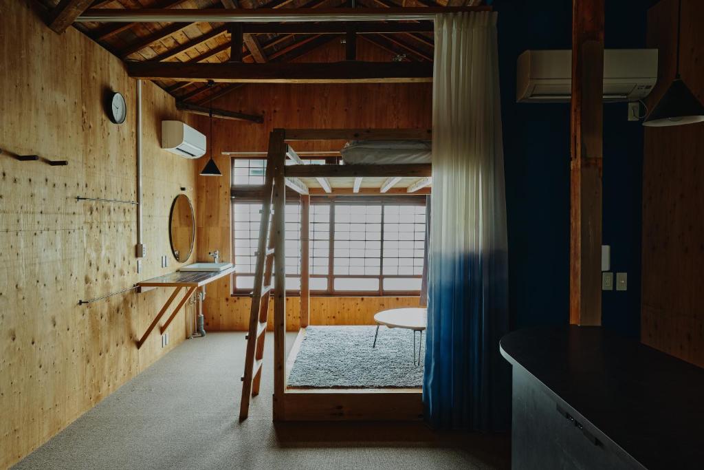 a room with a ladder and a bunk bed at まちの別邸 緝 shu in Kochi