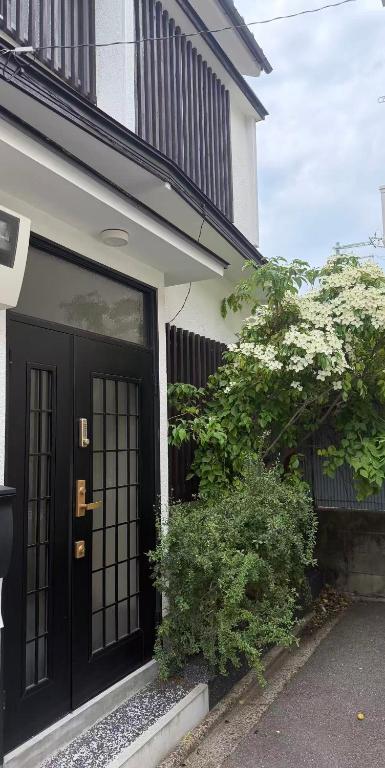a black door on the side of a house at WUMETEI Japanese-style lodge in Kyoto