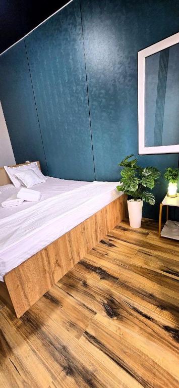 a large bed in a room with a wooden floor at Centre Cheap Hotel in Tashkent
