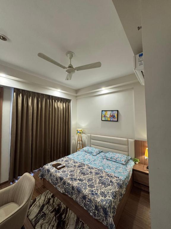 a bedroom with a bed and a ceiling fan at the Aurelia estate studio apartment Alpha 2 in Greater Noida