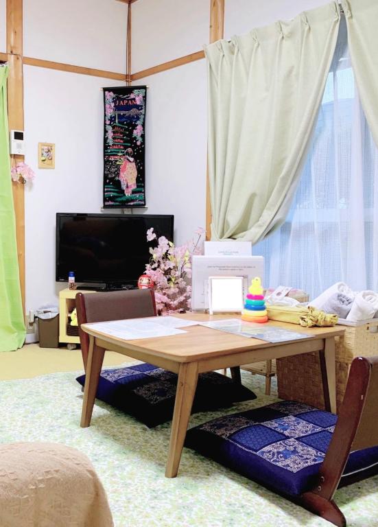 a living room with a wooden table and a tv at ヴィラ 奈良 with gift 小さなギフト付 奈良駅から15から20分 in Nara
