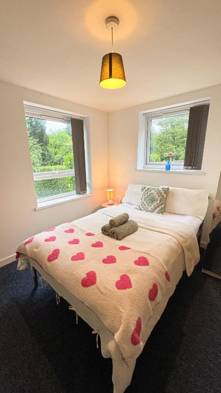 a bedroom with a bed with red hearts on it at Bambi Nest in Sketty