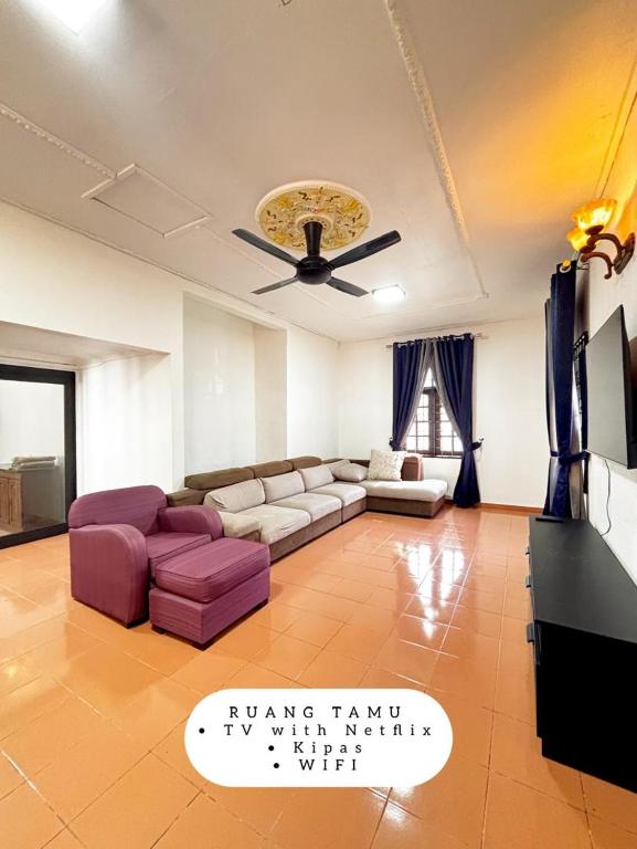 a living room with a couch and a ceiling fan at Harumi Guesthouse in Marang