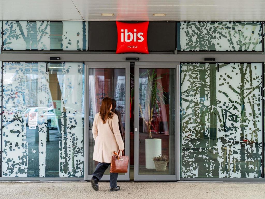 a woman walking in front of a ups store at ibis Heverlee Leuven in Leuven