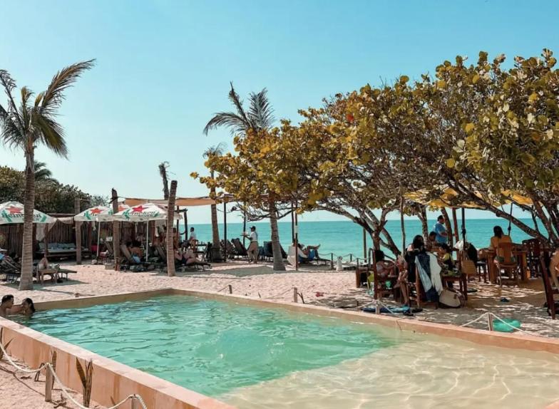 a swimming pool on a beach with people on the sand at Great location safe & beautiful w Beach Club in Mérida