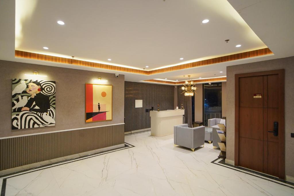a lobby with a waiting room with a painting on the wall at Hotel Shivora in Bathinda