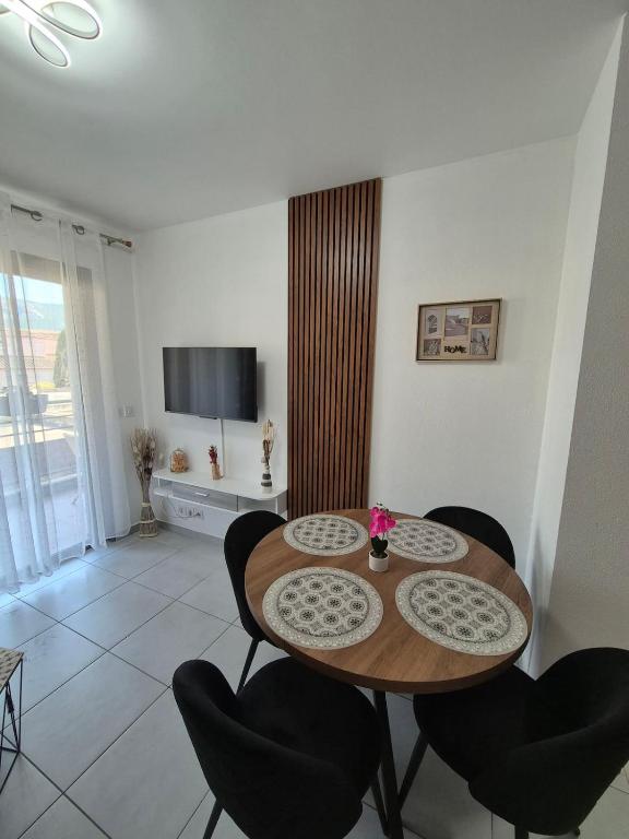 a dining room with a wooden table and chairs at Charmant T2 in Calvi