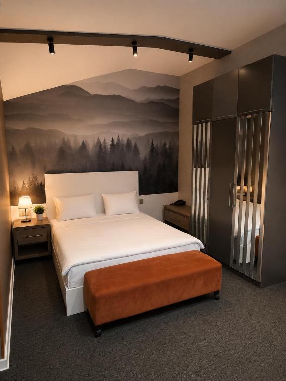 a bedroom with a bed and a painting on the wall at Central City Department Hotel in Baku