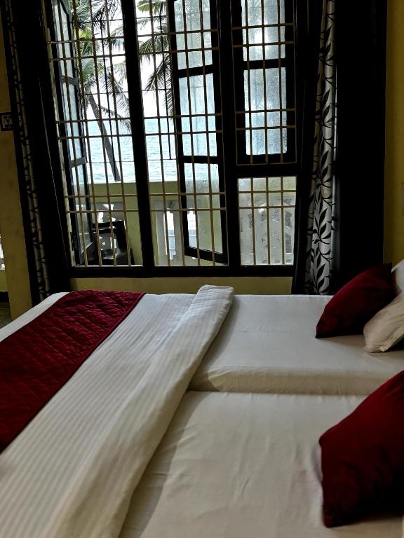 a bed in a room with a large window at Muthu Seaview Residency in Kuilapayam