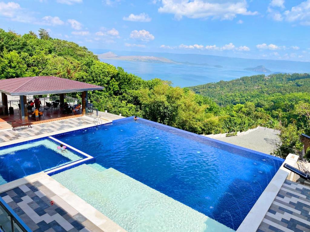a swimming pool with a view of the ocean at Highlights Taal Lake View Resort in Santol