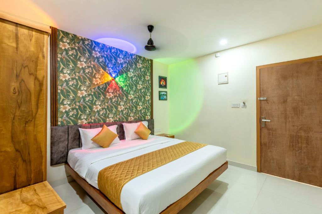 a bedroom with a bed with a large painting on the wall at Hotel Beverly Residency - Near Nileshwar Railway Station in Nīleshwar