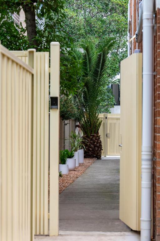 a wooden fence with a gate in front of a house at Canvas On Barkly Apartments St Kilda in Melbourne