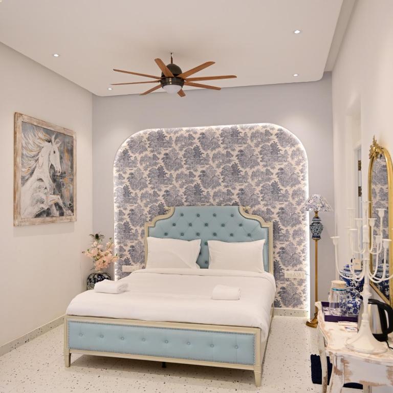a bedroom with a bed with a blue headboard at Greece In Blue in Kandivalli