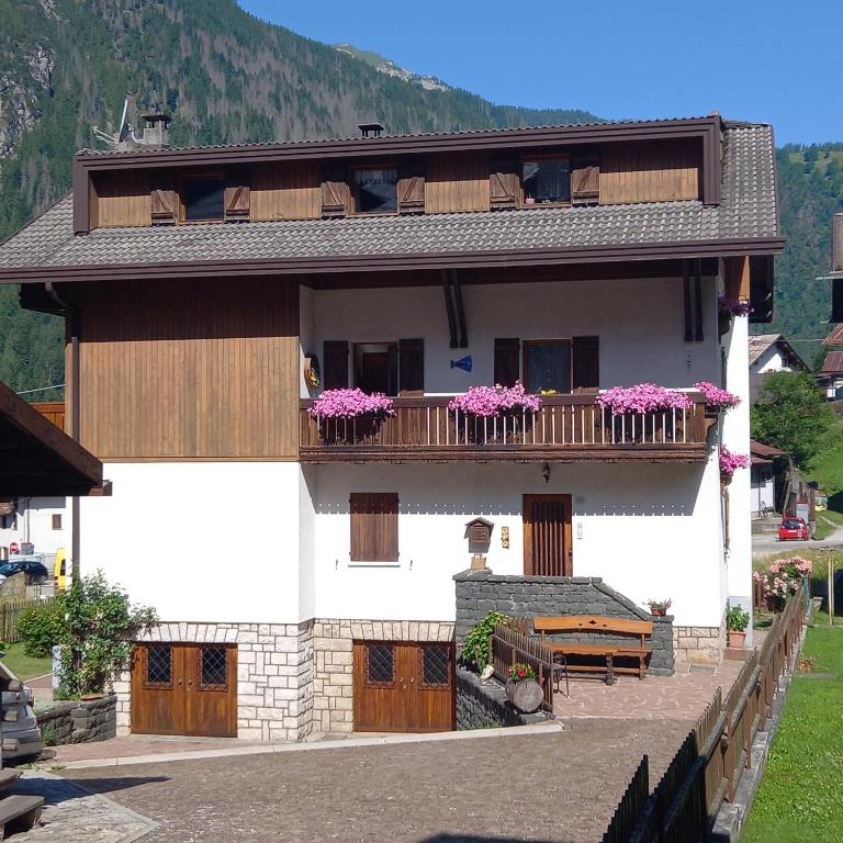 a house with a balcony with flowers on it at Dolomites Apartment Finestra sul Civetta in Alleghe