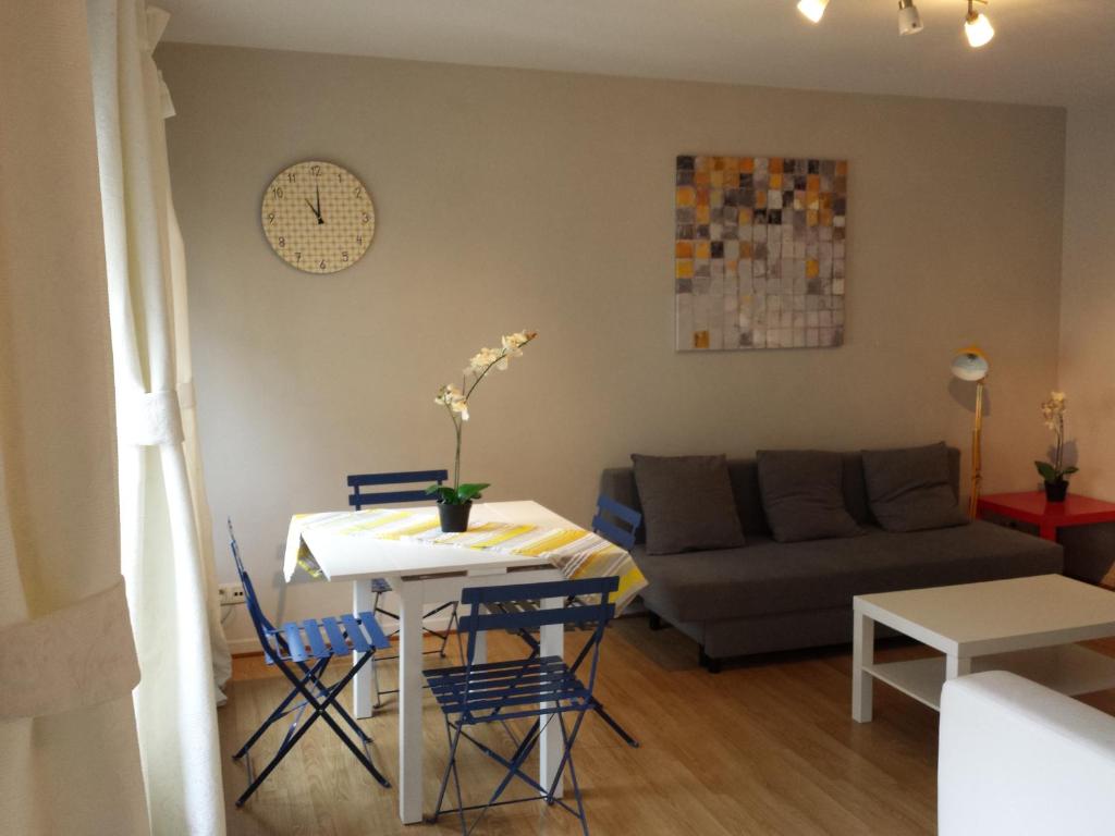 uma sala de estar com uma mesa e cadeiras e um sofá em Central Yellow Apartment em Bruxelas