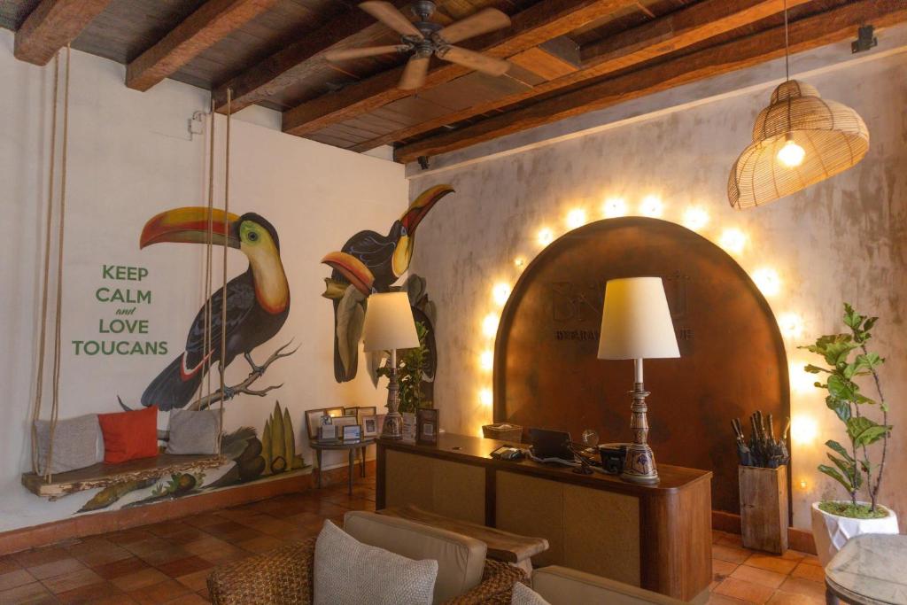 a living room with a wall with a painting of birds at Hotel Bantu by Faranda Boutique, a member of Radisson Individuals in Cartagena de Indias