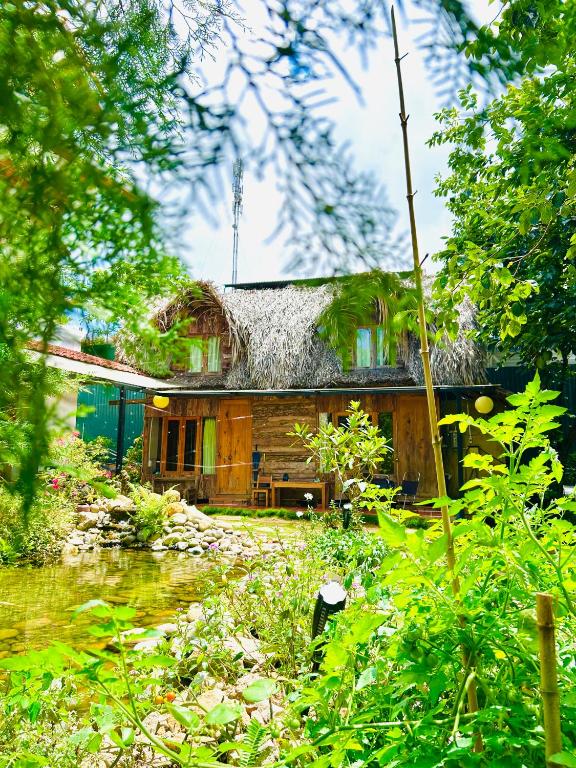an old house is seen through the trees at Đà Lạt Củi Homestay in Da Lat