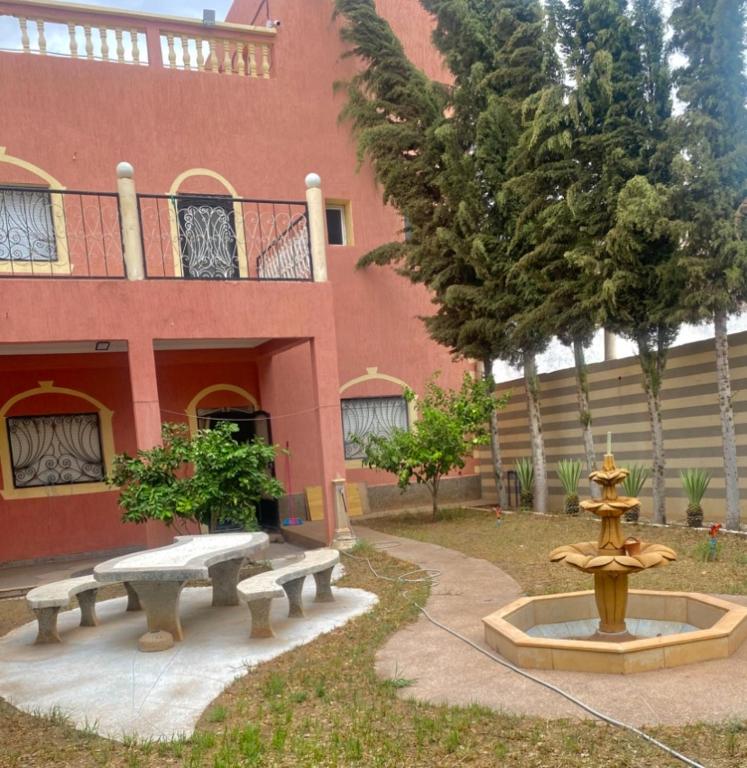 a building with a fountain in front of a building at Villa HMR ⵥ in Rhorm el Alem