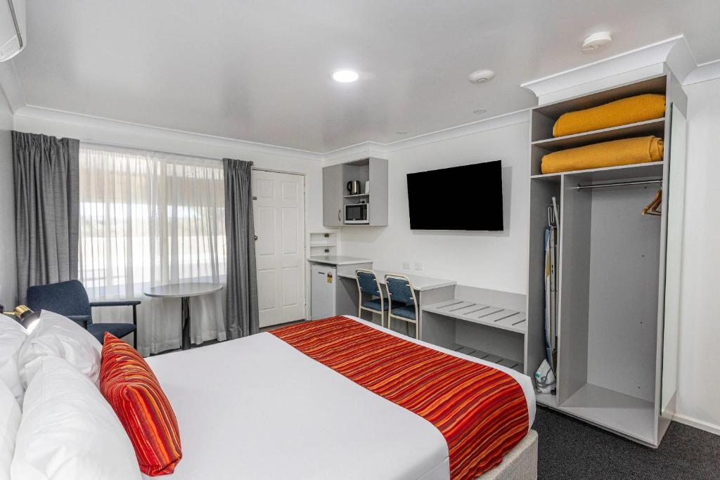 a hotel room with a bed and a desk at Econo Lodge Alabaster Motel Cowra in Cowra