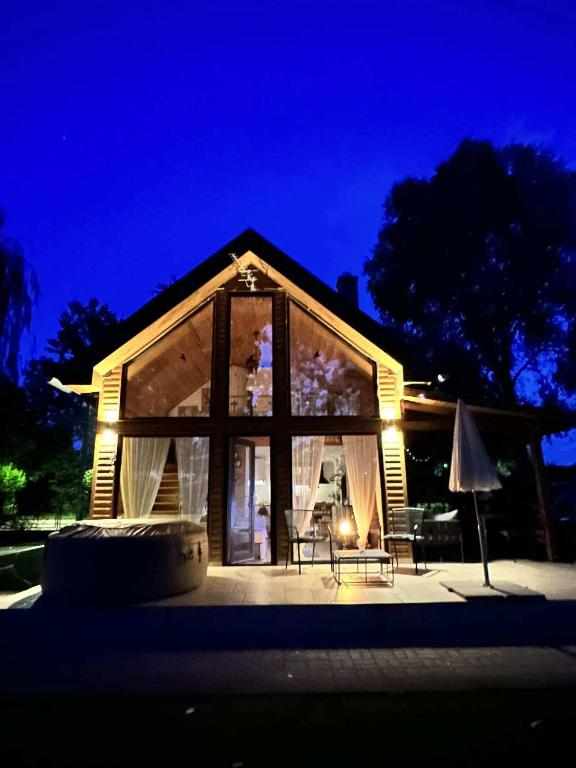 a small house with a lit up front at night at Csendliget Villas Abádszalók in Abádszalók