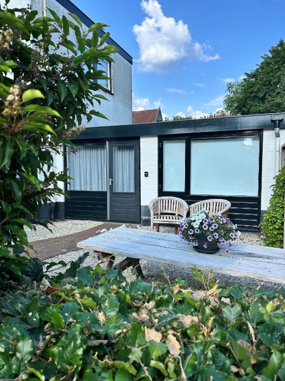 two chairs and a picnic table in front of a house at 't Achterhuis (8 persons) in Otterlo