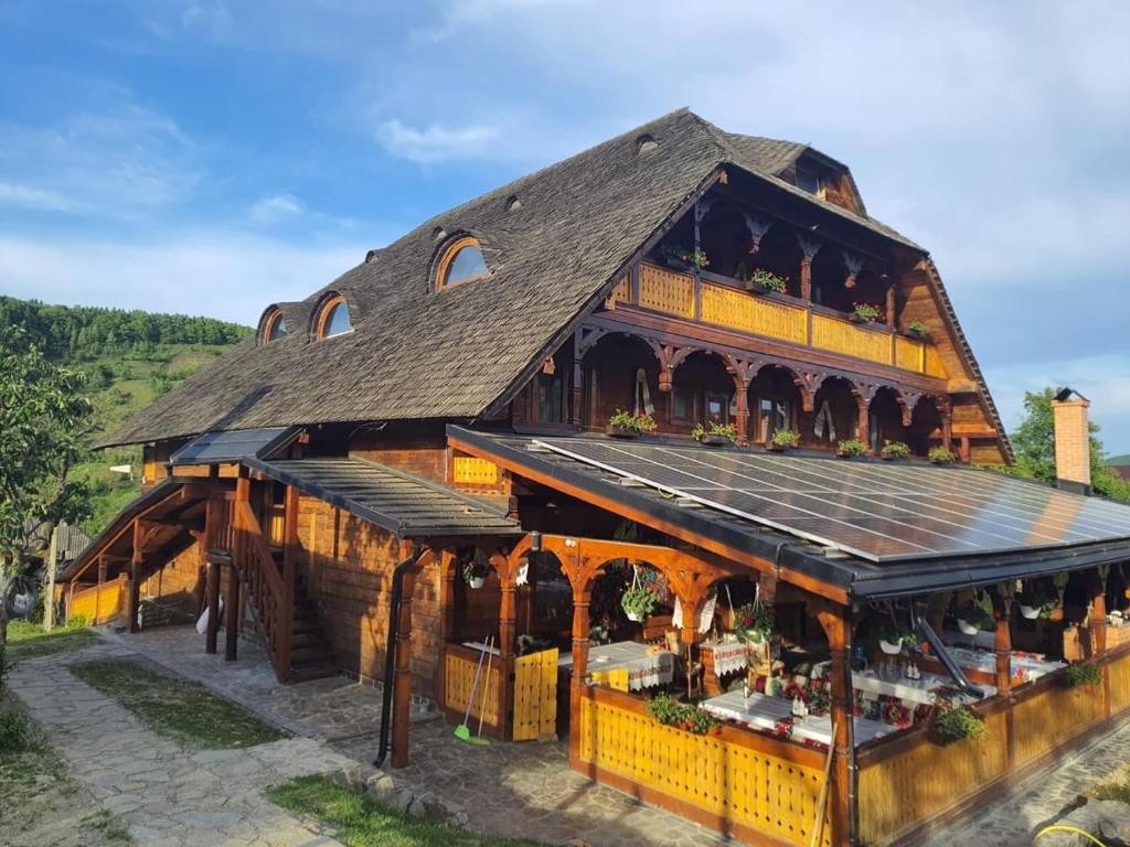 a large wooden building with a large roof at Pensiunea Codrea - Wagner in Lazu Baciului