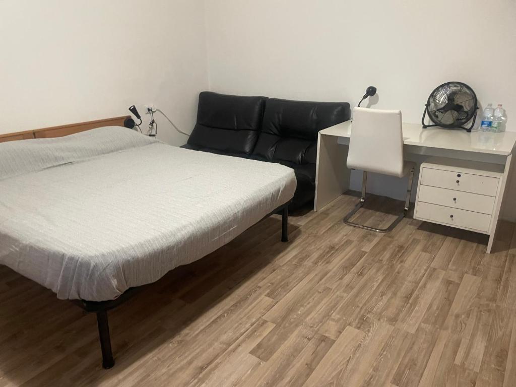 ein Schlafzimmer mit einem Bett und einem Schreibtisch in der Unterkunft Affittacamere D&B in Pogliano Milanese