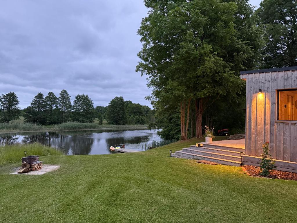 a cabin on the shore of a lake at Pagalėlių namai in Voveriai