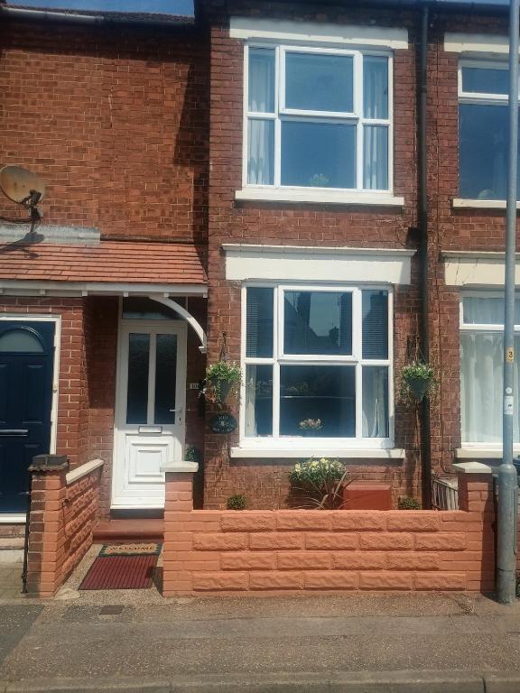 a brick house with a white door and windows at Bide a Sea in Gorleston-on-Sea