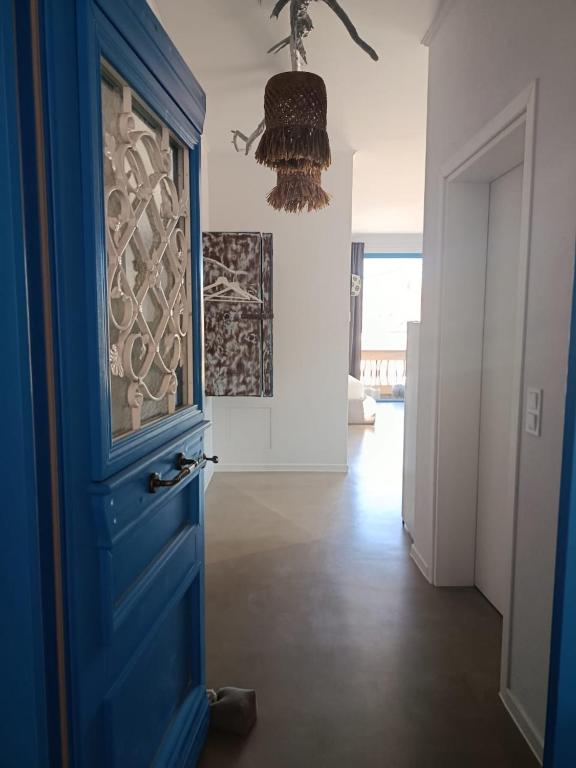 eine blaue Tür in einem Wohnzimmer mit einem Kronleuchter in der Unterkunft Hellas4ever in Chrysoupolis