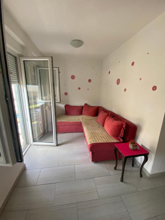 a living room with a red couch and a window at APARTMAN SEVEN free parking in Gornja Toplica
