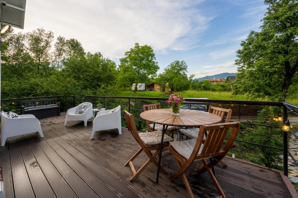 a wooden deck with a table and chairs at Forest House Premium Breaza in Breaza de Sus