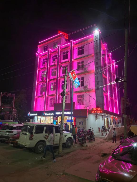 a pink building with a person walking in front of it at Hotel Sky View in Aurangābād