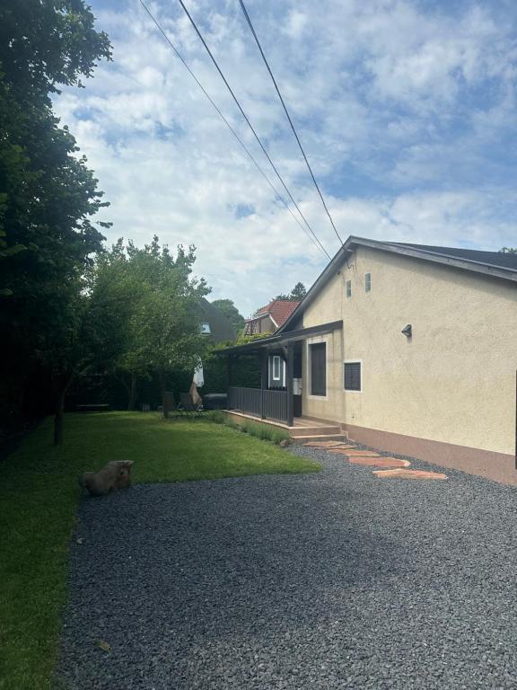 a dog laying in the grass next to a house at Gréta Apartman in Ábrahámhegy
