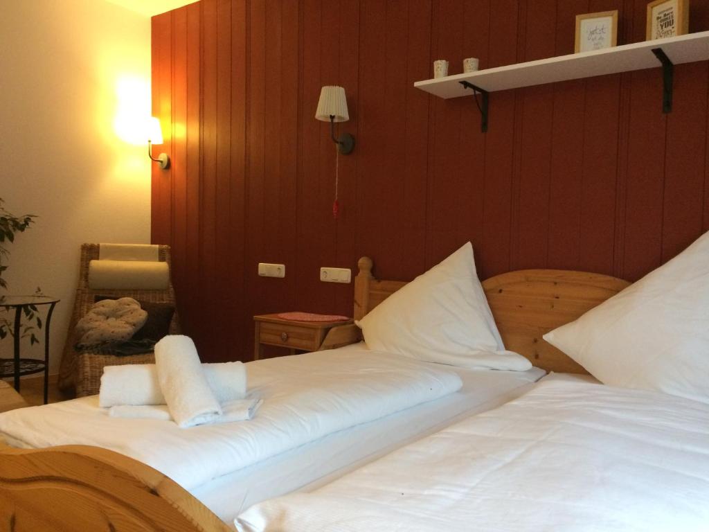 a bedroom with two beds with white sheets at Pension Glücklich in Horgenzell