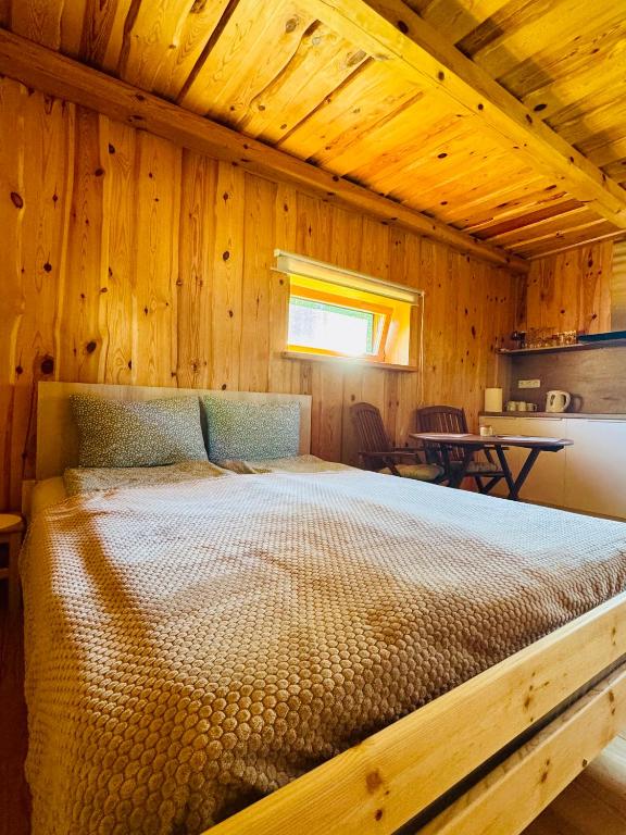 a bedroom with a bed in a wooden cabin at Stripeikių Bitė in Varniškės I