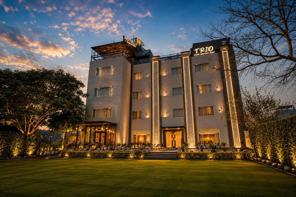 ein Hotel mit einem Rasen vor dem Gebäude in der Unterkunft Hotel Three Seasons in Vrindāvan