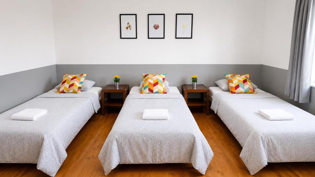a room with four beds with pillows on them at Tanie spanie na Naramowicach- ZAMELDOWANIE BEZOBSŁUGOWE - in Poznań