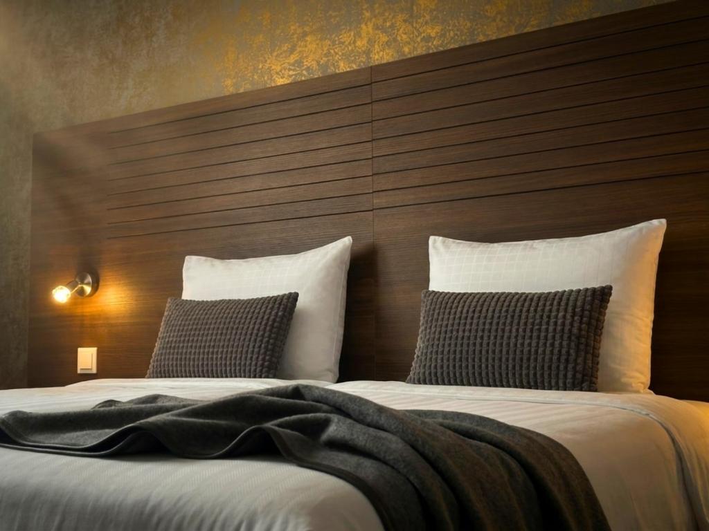 a hotel room with two beds and a headboard at A-Hotel Oosterhout in Oosterhout