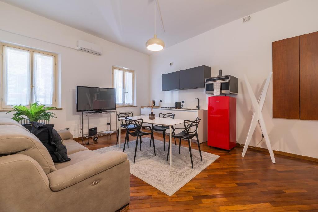 a living room with a table and a red refrigerator at Effealatapartments - Appartamento del Duca in Senigallia
