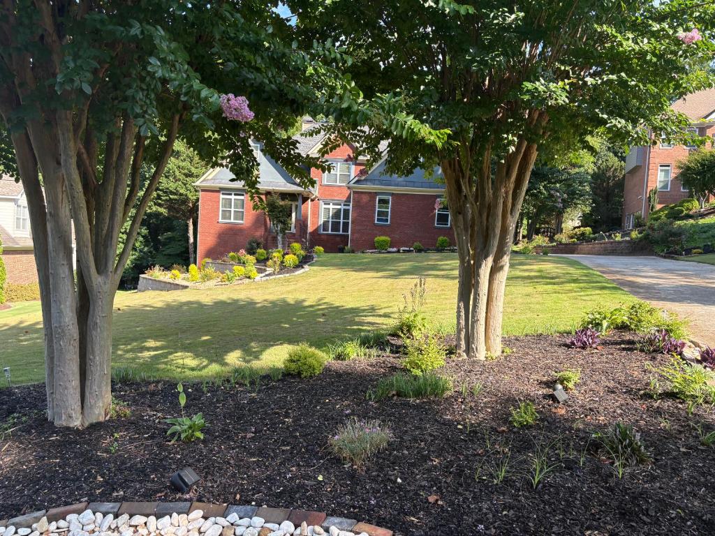 a yard with two trees in front of a house at Karibuni Braselton in Braselton