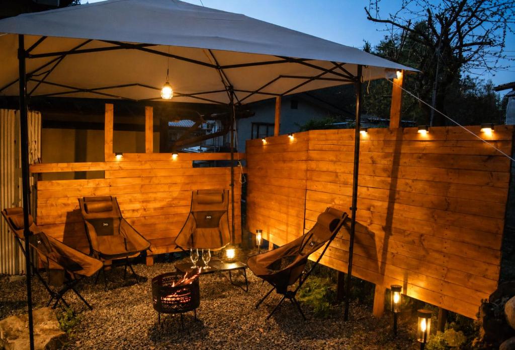a group of chairs under an umbrella with lights at Komorebi/こもれび in Takayama
