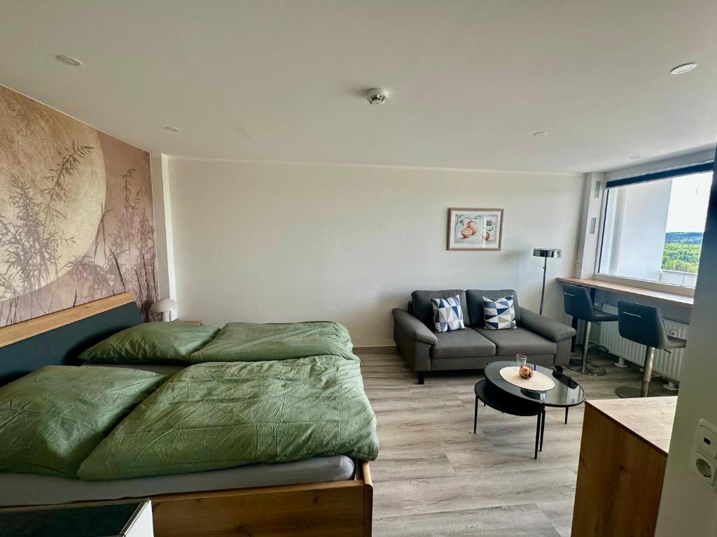 a bedroom with a bed and a couch and a table at Wolkenparadies in Altenau