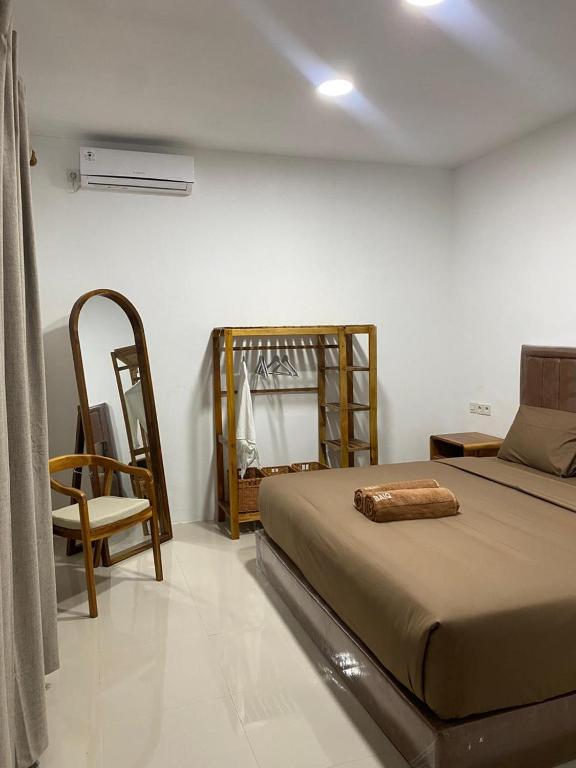 a bedroom with a bed and a chair at RUMAH BAIQ Villa in Kuta Lombok