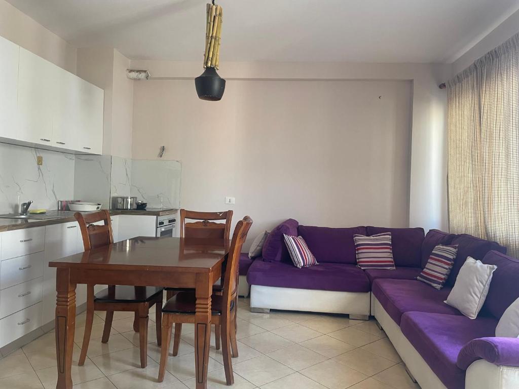 a living room with a purple couch and a table at Eretz in Tirana
