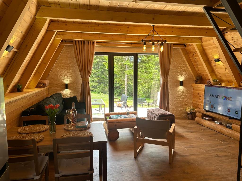 a living room with a table and a tv at Villa Aleksandra in Žabljak