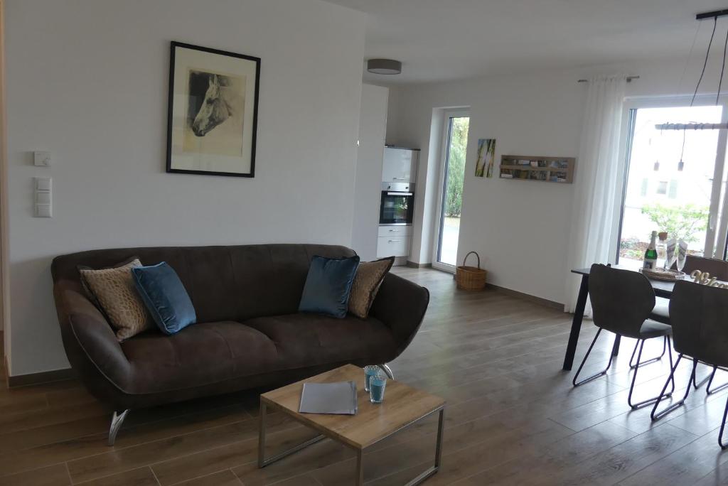 a living room with a brown couch and a table at Ferienwohnung Wolkenfeld in Kaisersesch