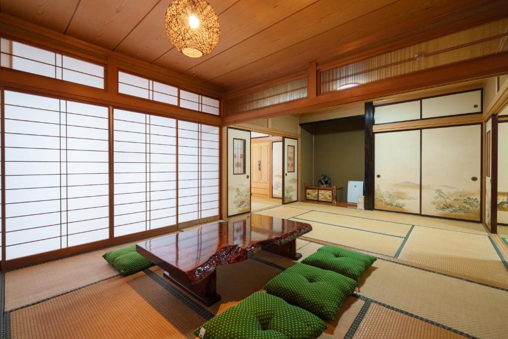 a living room with a table and green cushions at 民泊ａｉｋｏ in Fukushima